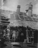 Inmates collected their ration of hot drinking water from this shed, which was affectionately called 'Dew Drop Inn'. I am in the line on the far left wearing shorts. (This photograph was taken by a war correspondent named Spitzer.)